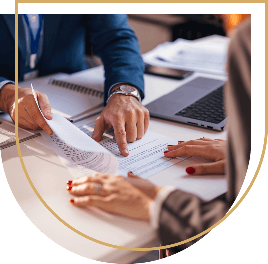Man in blue suit is pointing at a paper document. 