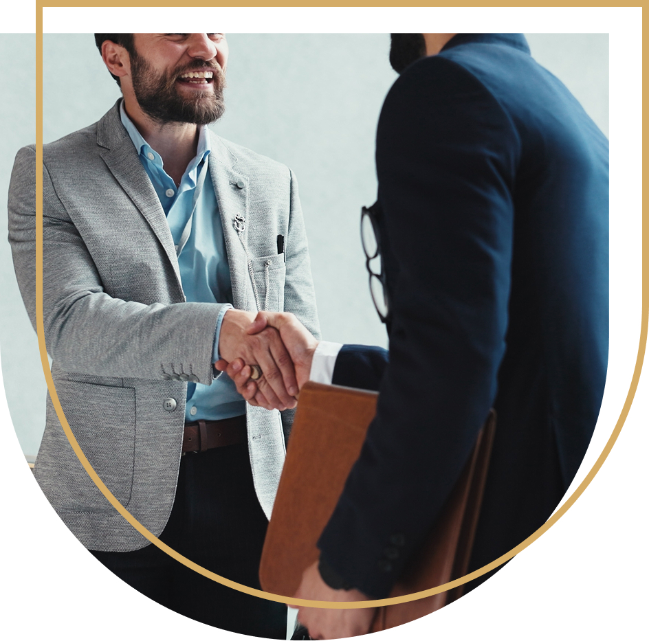 Two men in blue suits are shaking hands.